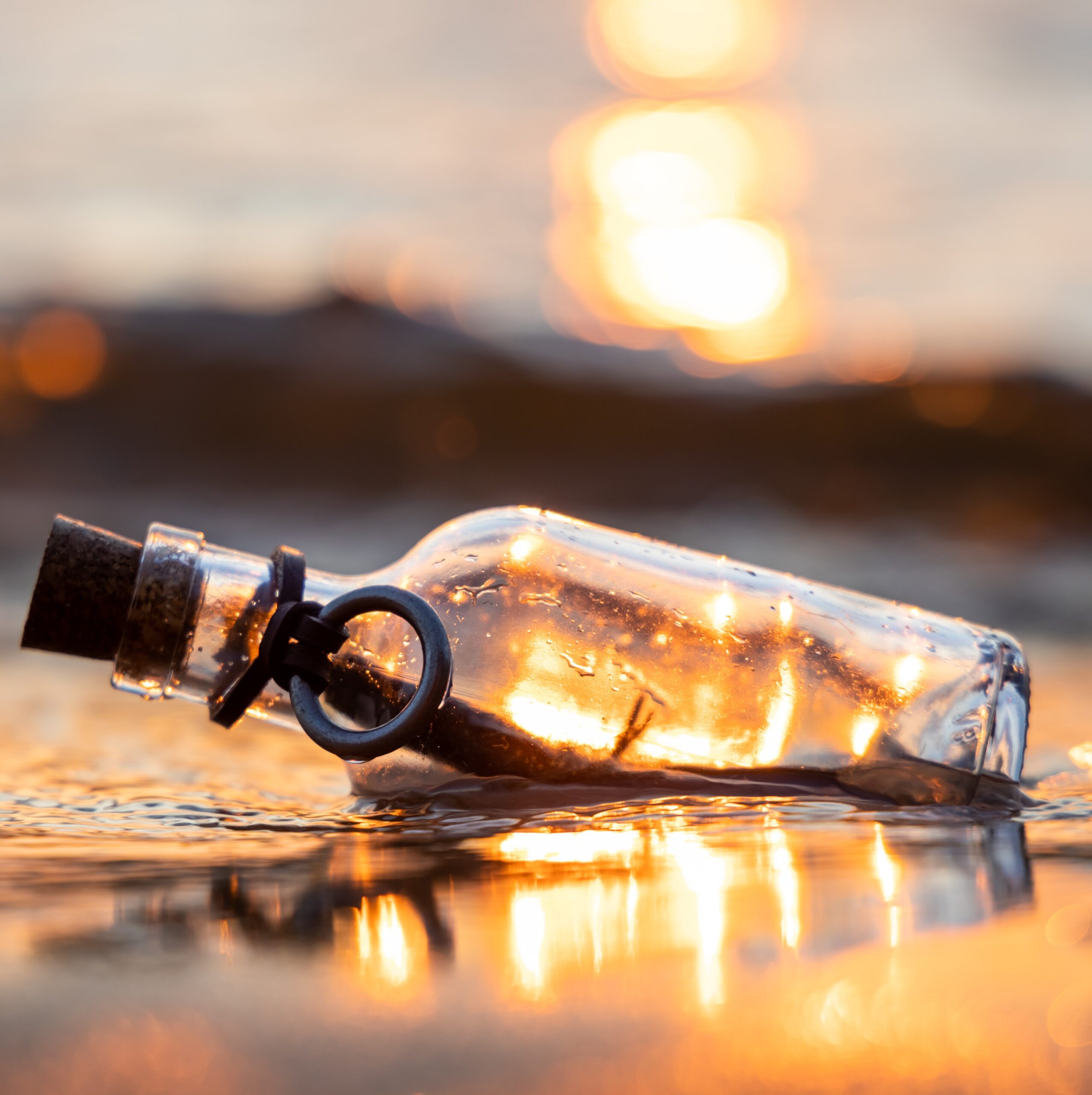 Fles op het strand bij bericht Herinneringen maken na de dood Rebel Uitvaart